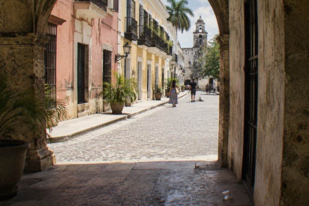 Pastel-colored colonial buildings lining a pedestrian street in the old town of Santo Domingo