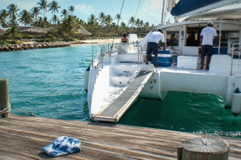 Catamaran at a departure dock in the late morning with boarding plank down