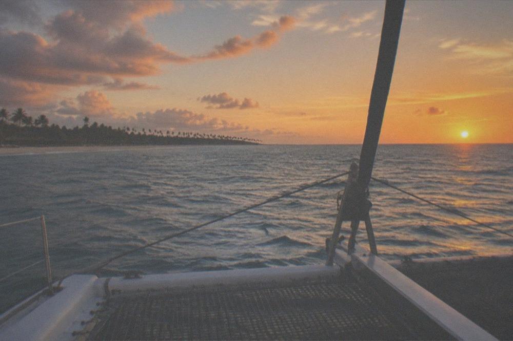 Open water horizon with warm sunset colors seen from a sailing catamaran