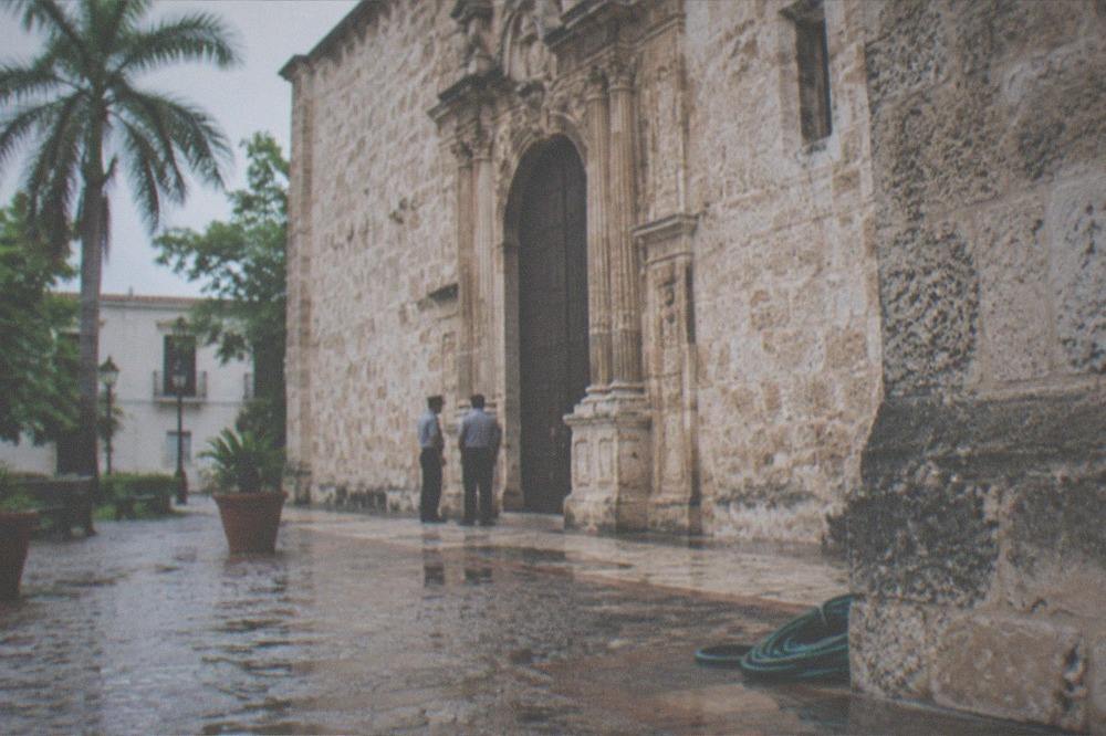 Uniformed officers standing near a colonial-era stone building