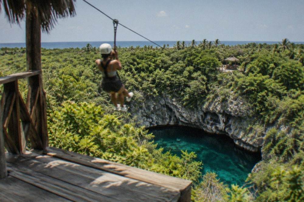 Zipline platform on a wooden tower overlooking tropical forest and cliffs