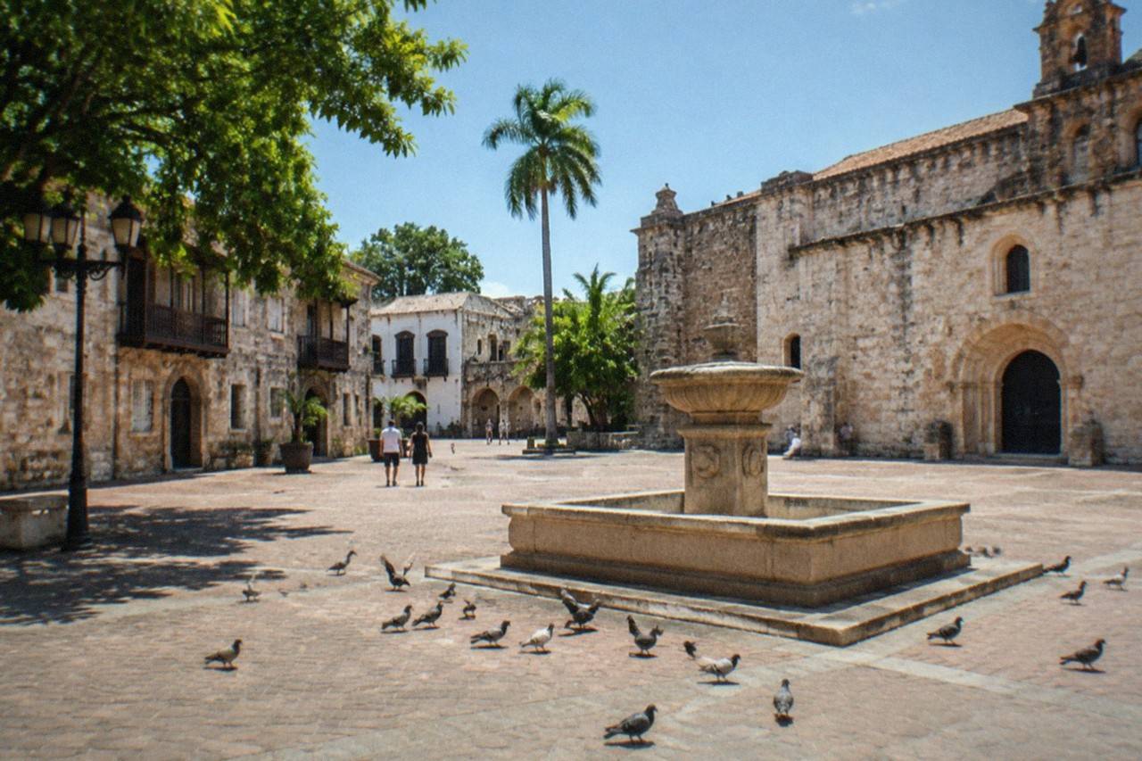 Cobblestone lane in Altos de Chavon, stone buildings and arches framing a view over the Chavon River valley.